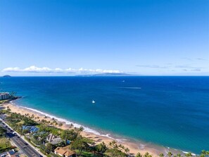 A coastal view with a beach, ocean, and distant mountains. - Quiet, comfortable and across from gorgeous Charley Young beach  (Kihei)