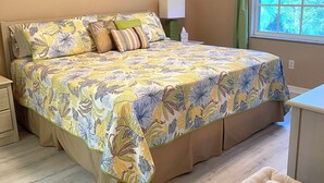 A bedroom with a bed, a nightstand, a bedside table, a window with curtains, and two framed pictures on the wall. - Close to Beaches, Restaurants & More!  Great Rates Too! (Bonita Springs)