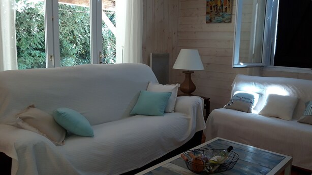 Two white sofas with light blue pillows, a lamp, and a table with a bottle and a basket. - Nice house classified 3 * Located in Dompierre Sur Mer, 5 Kms De La Rochelle (Dompierre-Sur-Mer)