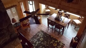 Un intérieur en bois comprenant un coin repas, un ventilateur de plafond et une cheminée.