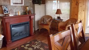Un salon chaleureux avec une cheminée, des meubles en bois et un mur en pierre.