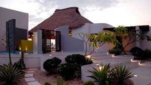 A resort with a thatched-roof structure, a pool, and landscaped gardens with cacti and palms. - Private Luxurious Resort Right on the Ocean - Casa De Los Sueños (Puerto Escondido)