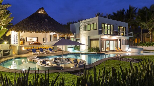 A modern resort with a pool, lounge area, and thatched-roof structure. - Private Luxurious Resort Right on the Ocean - Casa De Los Sueños (Puerto Escondido)