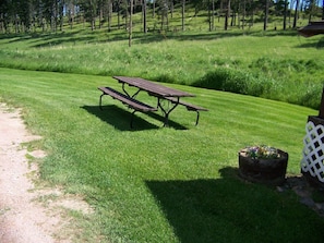 Enjoy a serene picnic amidst lush greenery and vibrant flowers in this peaceful outdoor space.