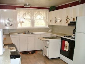 Enjoy cooking in this well-equipped kitchen with a black stove, sink, and ample countertop space.
