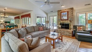 A spacious living room with a large sofa, a fireplace, and a ceiling fan. - Pet Friendly Home w/ Free Tennis & Screened Porch (Hilton Head Island)