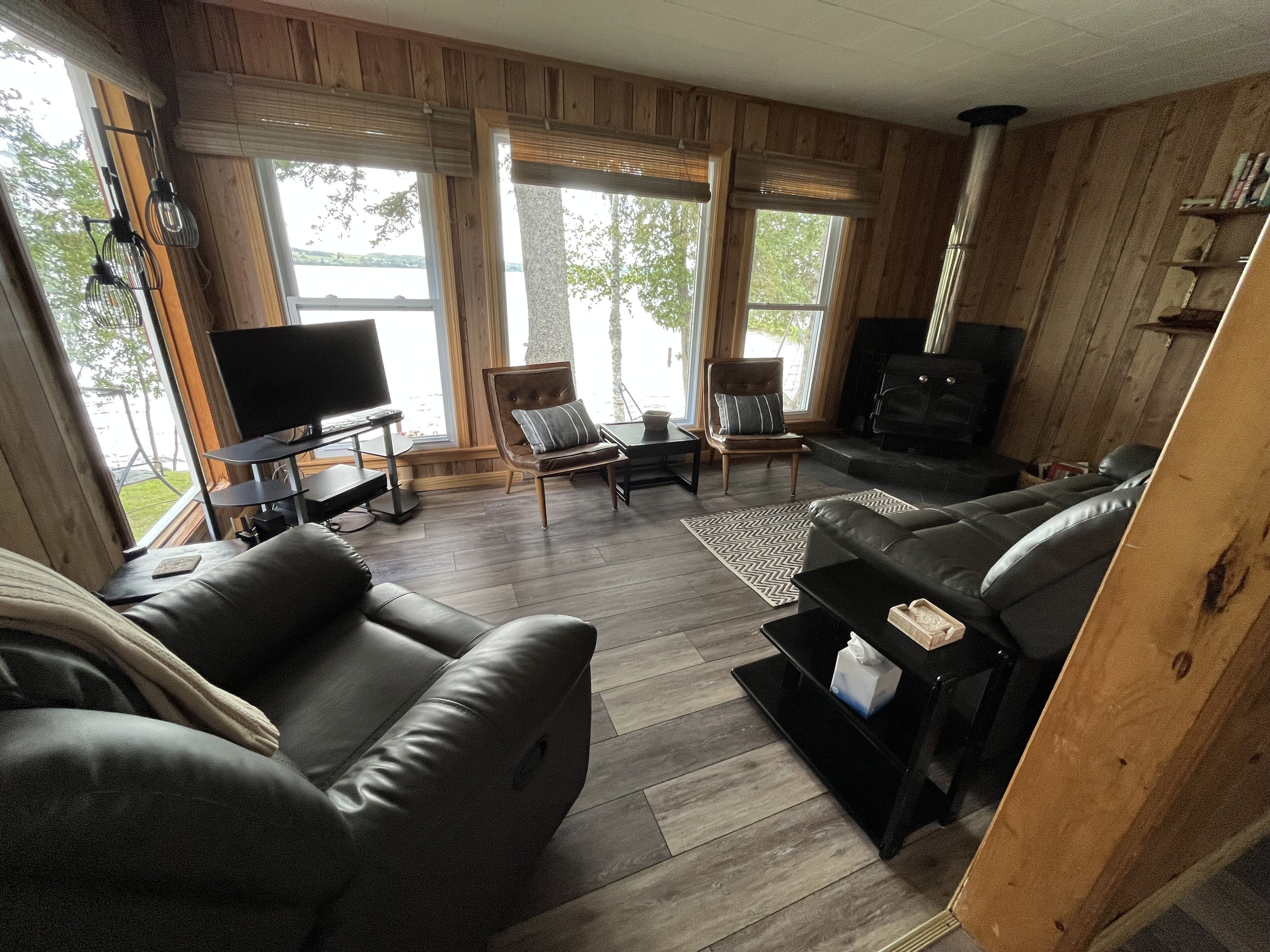 Una sala de estar acogedora con chimenea, sofás de cuero y televisor.
