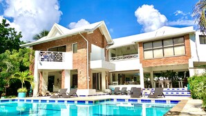 A two-story house with a swimming pool, a balcony, and a patio area.