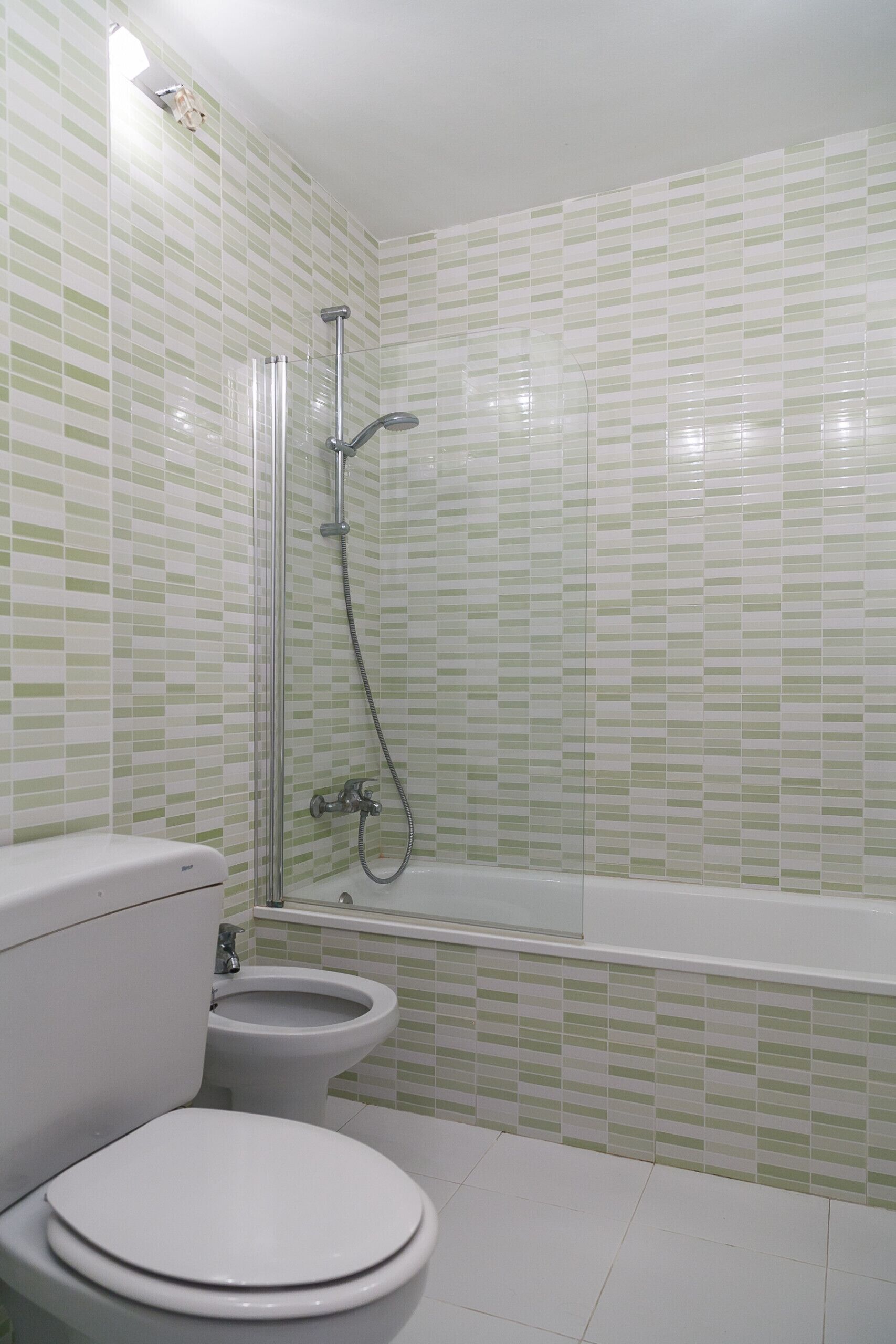 A bathroom with a toilet, bidet, and bathtub.