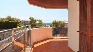 A balcony with a view of the sea, a tiled floor, and a metal railing. - Spacious apartment with sea views and pool - UHC MARINA MAR (Salou)