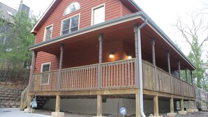 A two-story house with a wooden deck and a covered porch. - Convenient Prime Location, Exceptional reviews!! We would love to host you. (Pigeon Forge)