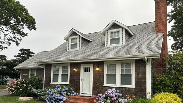 A two-story house with a brick chimney, dormer windows, and a front porch with steps. - Amazing Falmouth Heights House Just Steps Away from Beach (Falmouth)