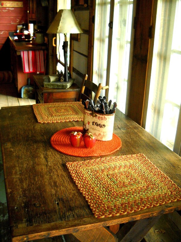 A rustic wooden table with woven placemats, a container labeled 'Farm Fresh Eggs', and a lamp. - Cabin rental near Cedar Point, Lake Erie, with Hot Tub, Campfire Pit, Gas Grill (Bellevue)