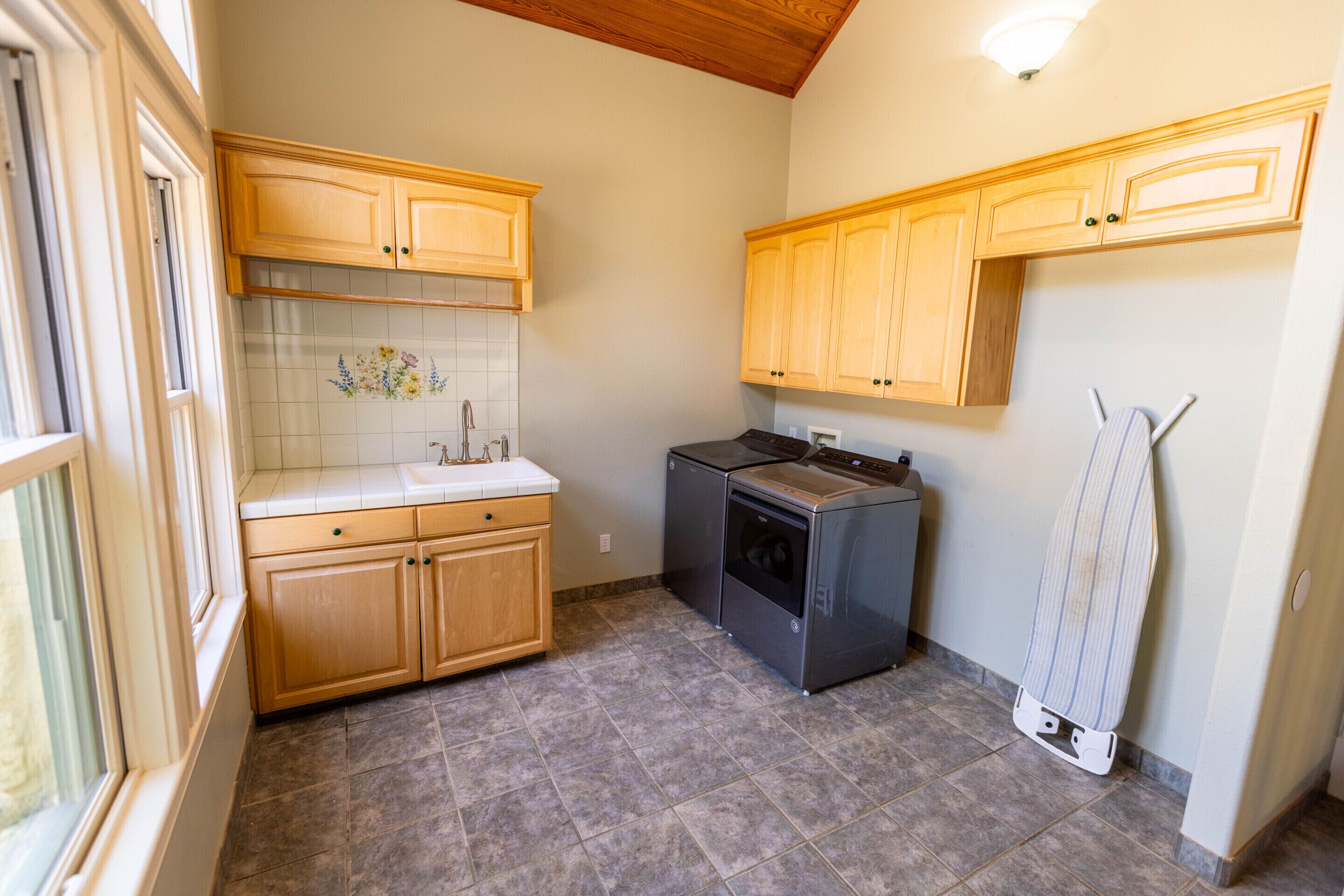 A kitchen with wooden cabinets, a built-in oven, and a tiled backsplash.