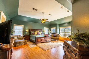 A bedroom with a bed, a dresser, a chair, a desk, and a ceiling fan. - Star Ranch Main Estate (Wimberley)