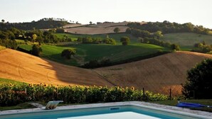 Una piscina con vista su dolci colline e campi.