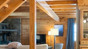 Un salon confortable avec un canapé, un téléviseur et une lampe.