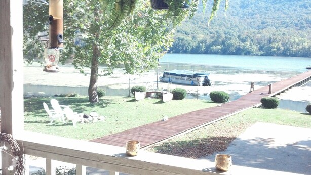 Une vue sur le lac, avec un quai, des bateaux et une promenade en bois.