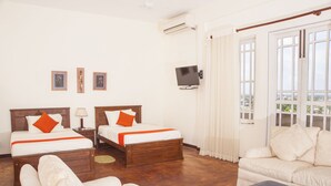 A hotel room with two beds, a sofa, a TV, and a window with curtains. - Peaceful Harmonious Condo Equipped Kitchen Two Bath Three Bedrooms Aircondition (Mount Lavinia)