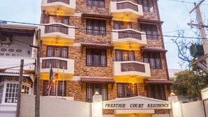 A multi-story building with balconies, a car parked in front, and a sign reading "Prestige Court Residence". - Peaceful Harmonious Condo Equipped Kitchen Two Bath Three Bedrooms Aircondition (Mount Lavinia)