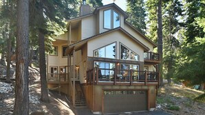 Ein zweistöckiges Haus mit Balkon, Garage und einer Treppe, die zu der oberen Etage führt.