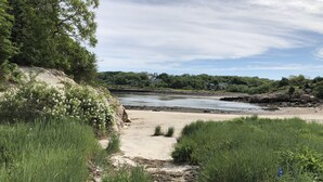 A coastal path leading to a beach with a wooden post and dense greenery. - Beautiful Oceanfront Home in Estate Setting Gloucester — FALL RENTAL AVAILABLE! (Gloucester)