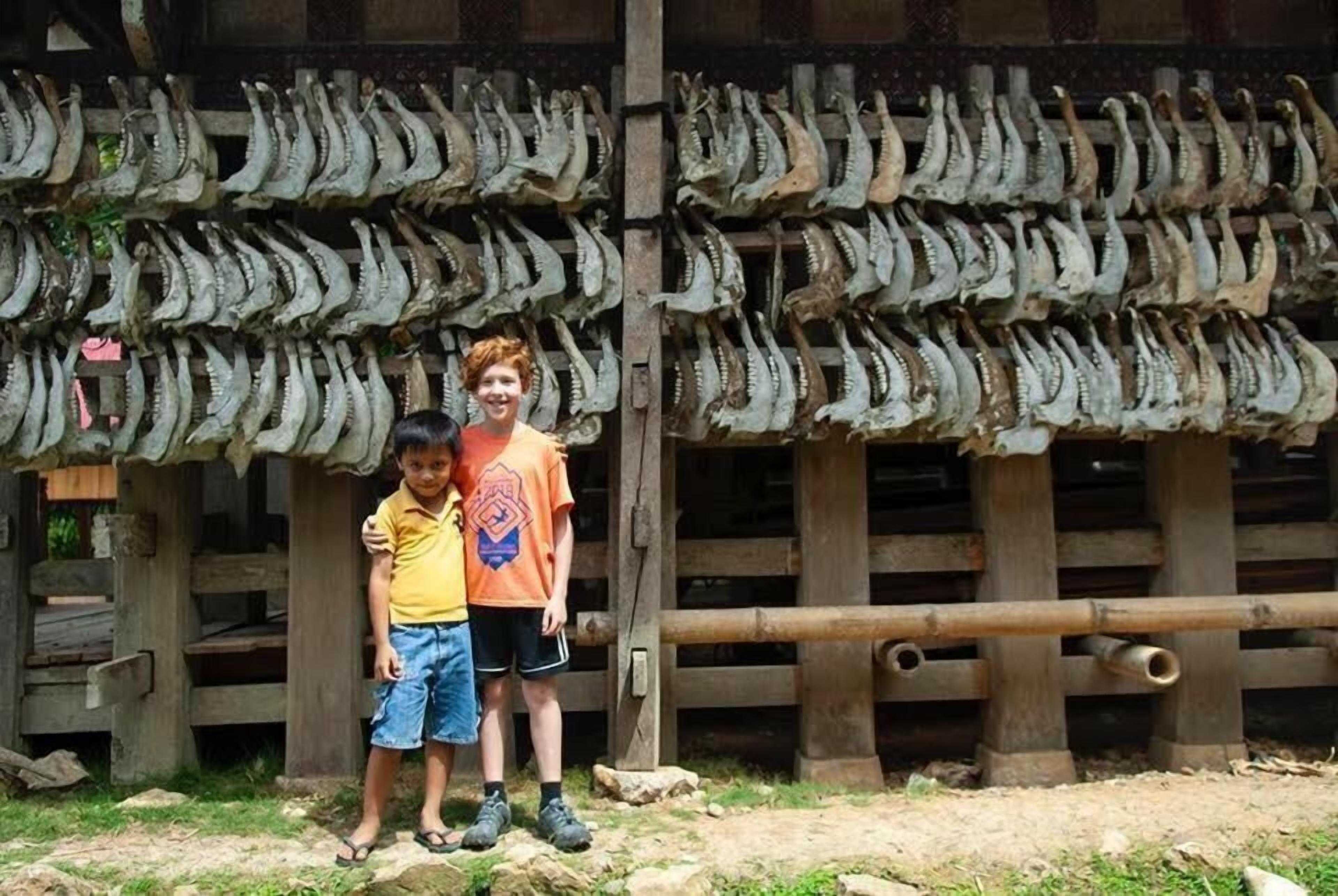 A rustic wooden structure with multiple rows of dried fish displayed on racks.