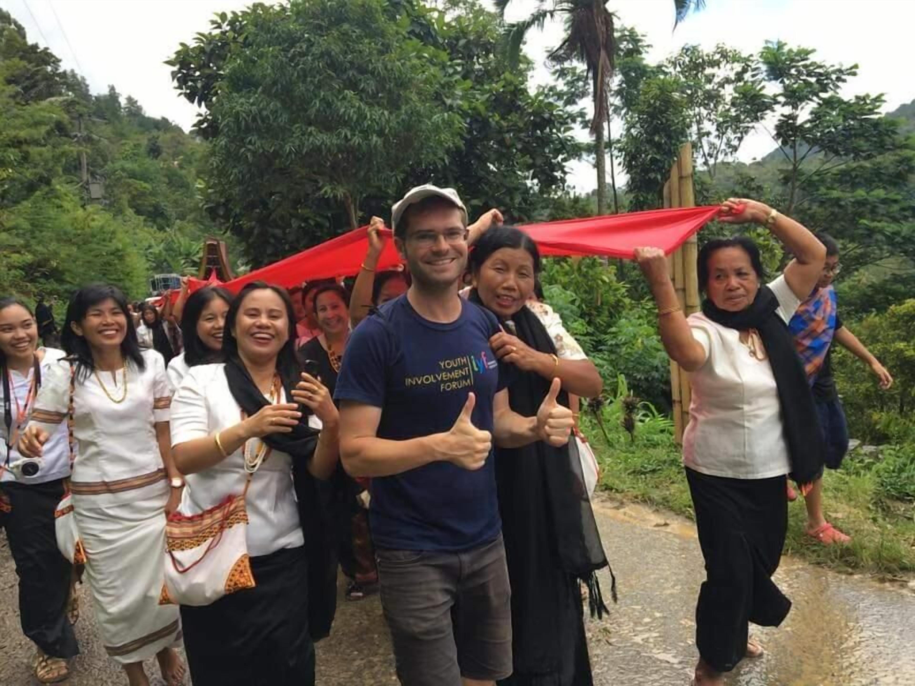A group of people walking on a path surrounded by greenery.
