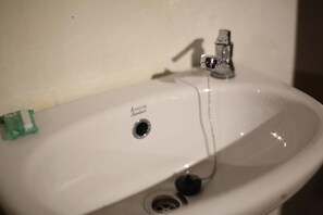 A white sink with a single faucet and a drain. - Mama Tia Family Homestay (Rinding Batu)