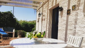 A white table with a bowl of fruit, white chairs, and a pergola with a blue cloth. - COUNTRY HOUSE IMMERSED IN A LEMONET 2 km from the sea and Noto - Wifi - climate (noto)