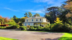 A two-story house with a tennis court in front. - Historic Hawkesbury Homestead Estate, Swimming Pool, Tennis court, Wine Country. (Blenheim)