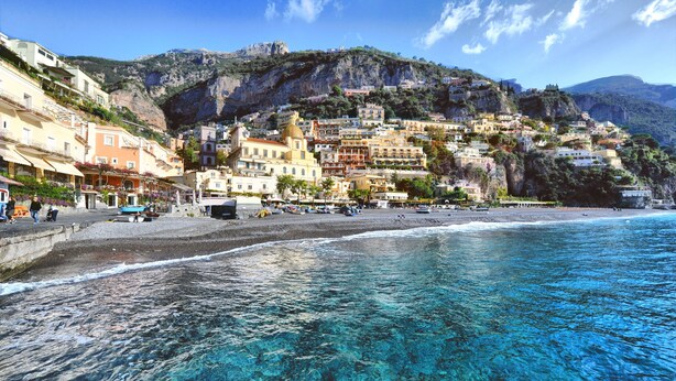 Un paese costiero con edifici su una collina che si affaccia sul mare.