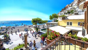 Una località costiera con una vivace passeggiata, un ristorante e vista sul mare.