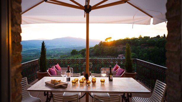 Une terrasse avec une table dressée pour le repas, offrant une vue sur un paysage magnifique.