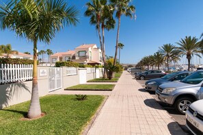 A residential street lined with palm trees and parked cars. - Marina Port 4 by VillaGranCanaria (Pasito Blanco)