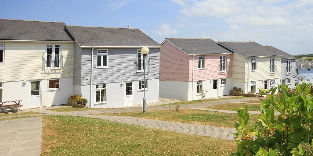 A row of townhouses with a paved walkway in between.