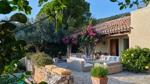 A patio area with outdoor furniture, a stone pool, and lush greenery. - High-end, sea view, 5 bed villa with Chef, maid, large pool + skippered boat (Moussata)