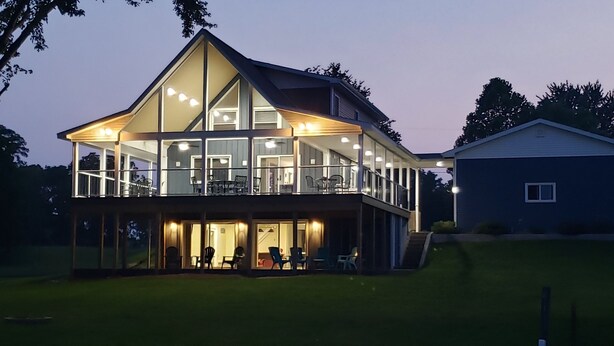A modern two-story house with a balcony, large windows, and a well-lit interior. - Paradise - Coldwater/North Lake Rental - Monthly/Weekly /4 day off season (Coldwater)