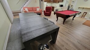 A pool table in a room with a sofa, a red chair, and wooden cabinets. - Paradise - Coldwater/North Lake Rental - Monthly/Weekly /4 day off season (Coldwater)