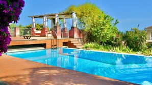 Ein Pool mit einer Pergola und Stufen zum Wasser.