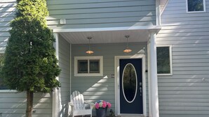 A house with a dark blue front door, white porch steps, and a white chair. - 5BR, 5BA on cul-de-sac, Big Pool,  jacuzzi, gym,  beautiful bay beach (Hampton Bays)