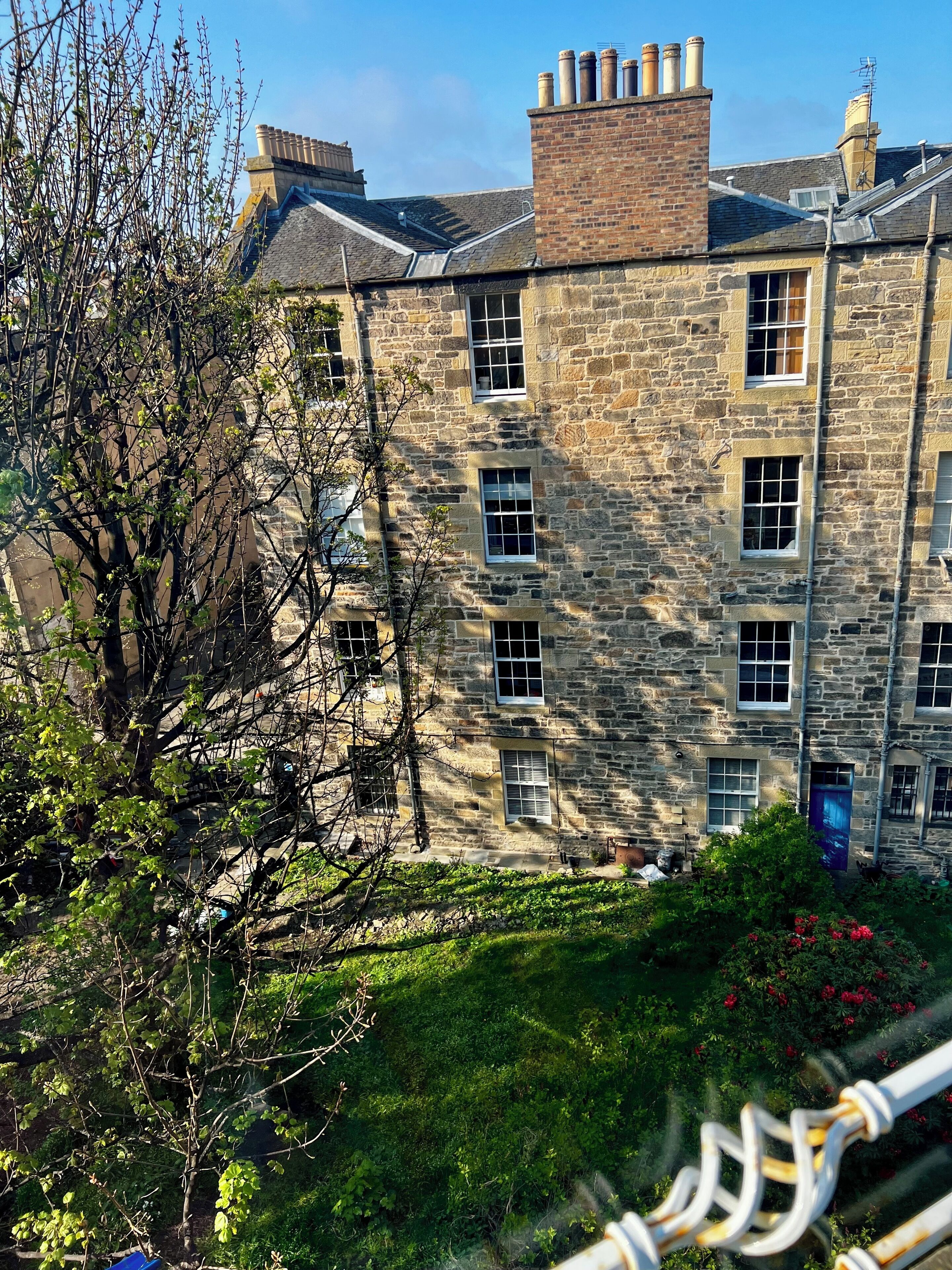 A stone building with multiple windows and a chimney.