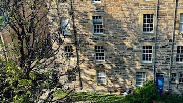 A stone building with multiple windows and a chimney.