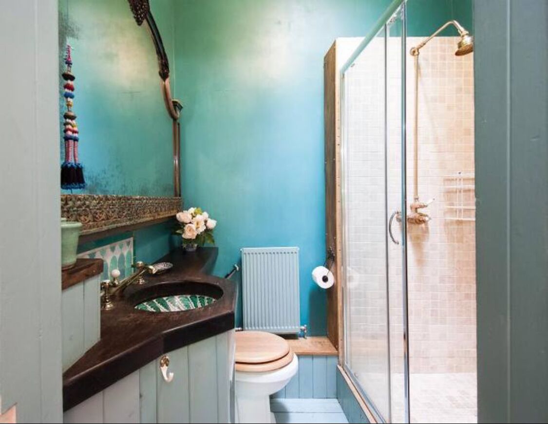 A compact bathroom with a shower, a toilet, and a sink.
