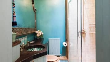 A compact bathroom with a shower, a toilet, and a sink.