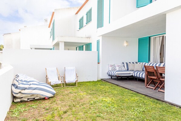 A courtyard with a sofa set, a small table, and two chairs.