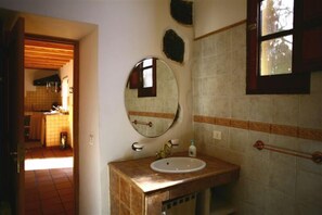 Ein Badezimmer mit Waschbecken, Spiegel und Fenster.