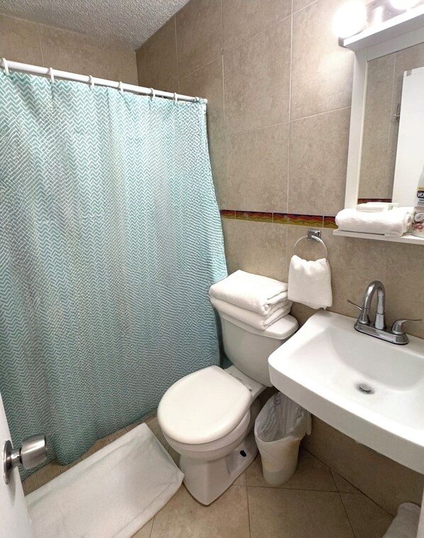 Ein Badezimmer mit Toilette, Waschbecken und Duschvorhang.