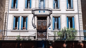 A two-story building with a symmetrical facade, a central entrance with a decorative iron gate, and blue shutters on the windows. -  Villa Celine,  a Bed & Breakfast with four bedrooms, garden and  swimming pool (Saint-Laurent-De-La-Cabrerisse)