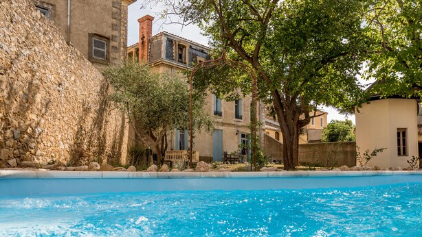 A swimming pool with clear blue water, surrounded by stone walls and trees. -  Villa Celine,  a Bed & Breakfast with four bedrooms, garden and  swimming pool (Saint-Laurent-De-La-Cabrerisse)